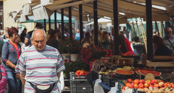 Photo of  Farmer's market in central Kosice, with people exploring the stalls that are packed with fruit and vegetables.