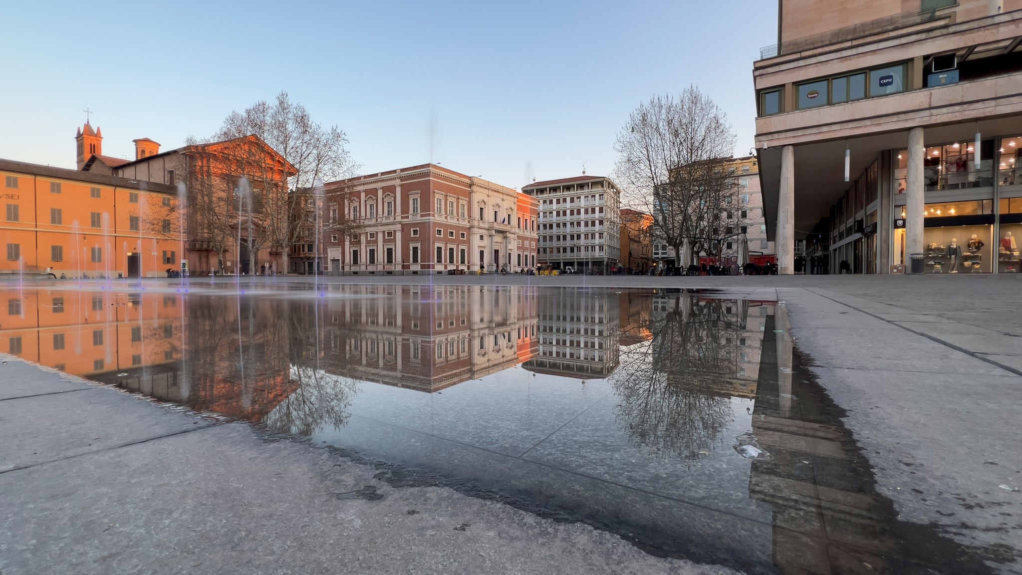 photo of reggio Emilia piazza della Vittoria reflection of the fountain at sunset. High quality photo