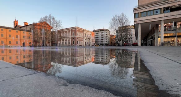 photo of reggio Emilia piazza della Vittoria reflection of the fountain at sunset. High quality photo