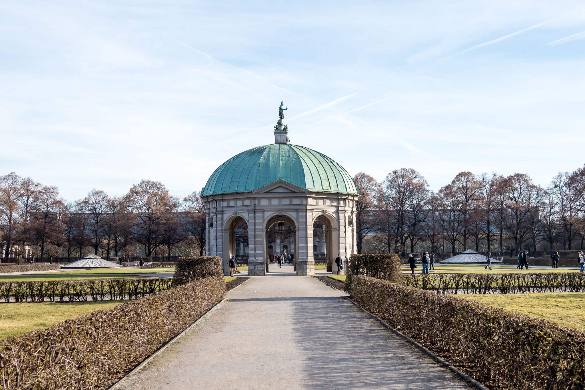 photo of view of Germany, Bavaria, Munich, Hofgarten: Winter scene of famous Court Garden (Schlossgarten) and Temple of Diana (Dianatempel) in the German city center of the Bavarian capital with white snow, blue sky.,Munich Germany.