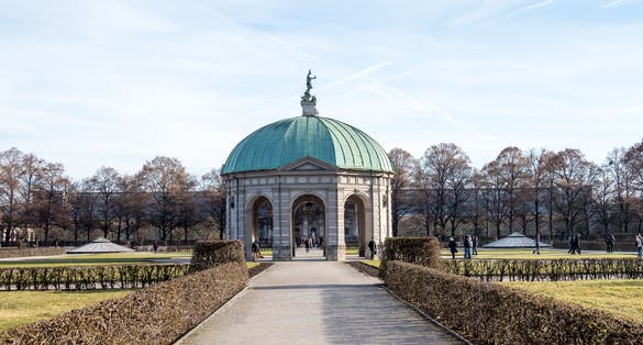 photo of view of Germany, Bavaria, Munich, Hofgarten: Winter scene of famous Court Garden (Schlossgarten) and Temple of Diana (Dianatempel) in the German city center of the Bavarian capital with white snow, blue sky.,Munich Germany.