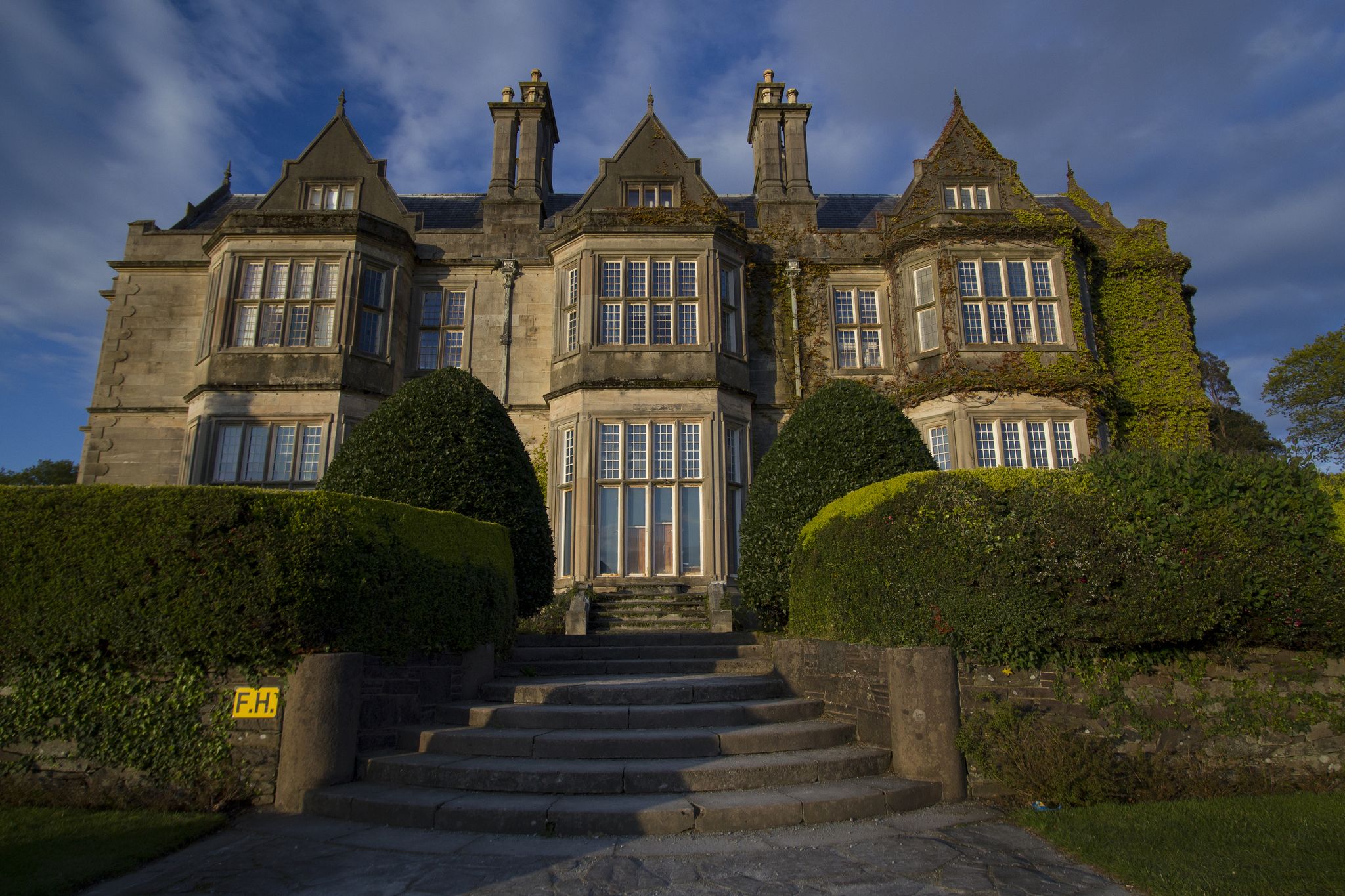 photo of Front entrance into Muckross Abbey House with sunset lightning located neary city of Killarney in Ireland