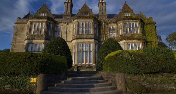 photo of Front entrance into Muckross Abbey House with sunset lightning located neary city of Killarney in Ireland