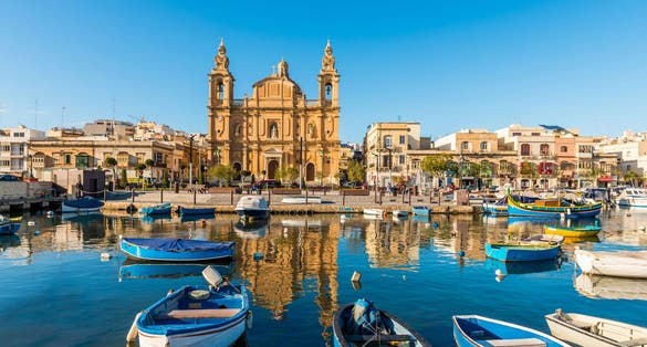 Photo of small harbor and baroque church in Sliema, on the island of Malta.