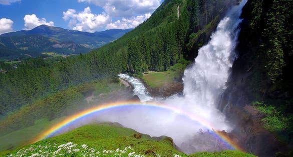 Photo of beautiful rainbow in Krimml Waterfalls and the surroundings forest in Krimml, Austria.