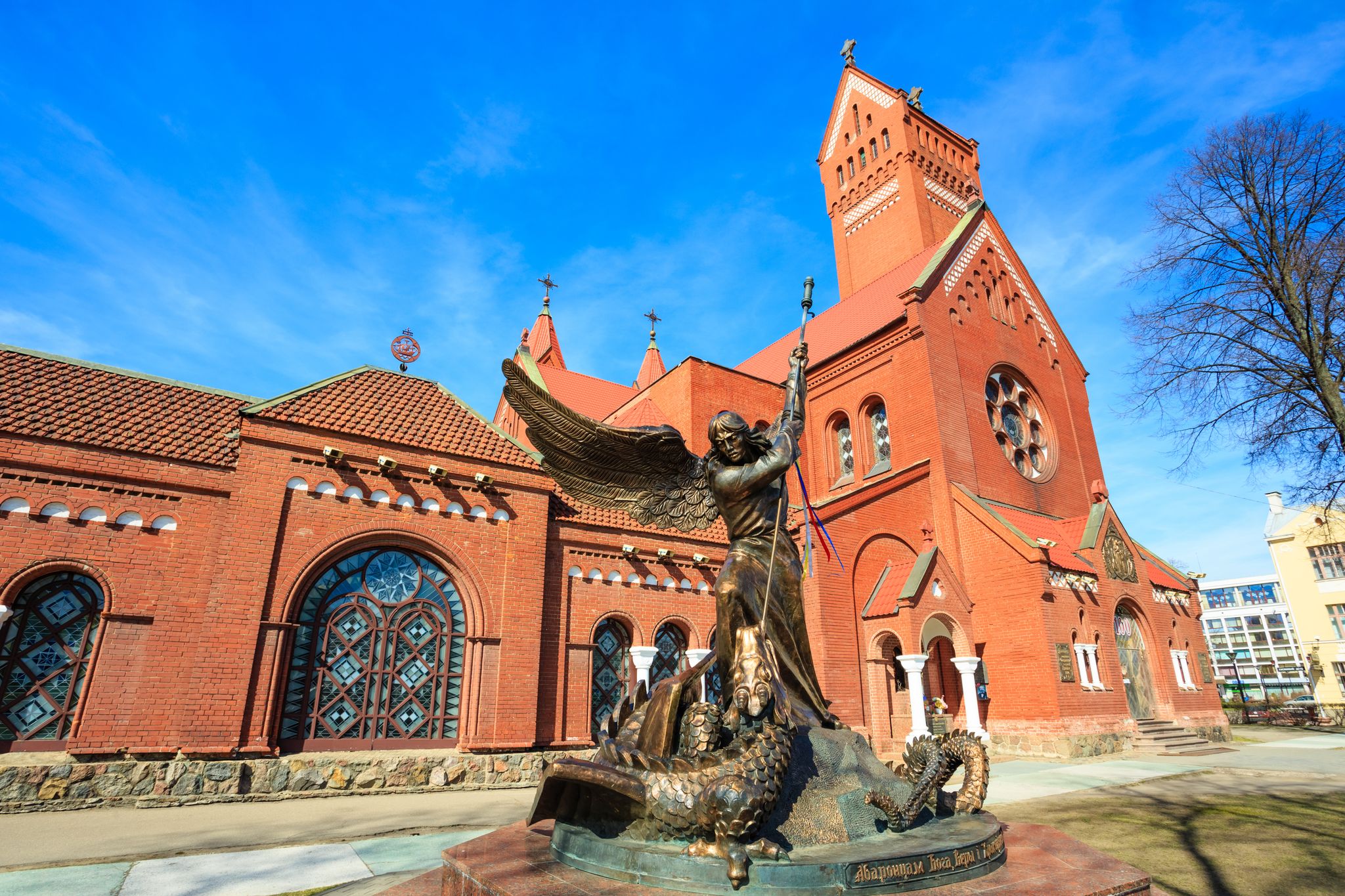 Photo of Statue of Archangel Michael with outstretched wings, thrusting spear into a dragon before Catholic Church of St. Simon and St. Helena.