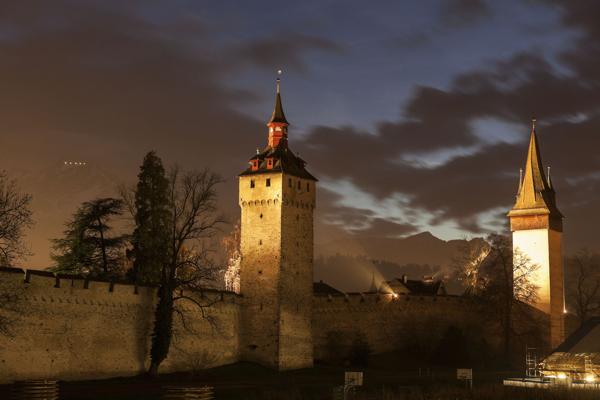 photo of Museggmauer it's a old city wall and towers at night in Luzern, Switzerland.