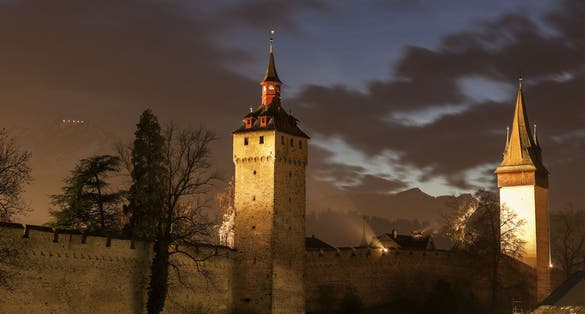 photo of Museggmauer it's a old city wall and towers at night in Luzern, Switzerland.