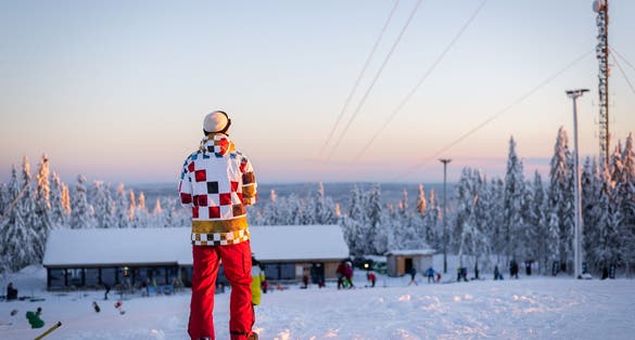 photo of skier/snowboarder in Oslo winter park during winter holidays at sunset in Norway.