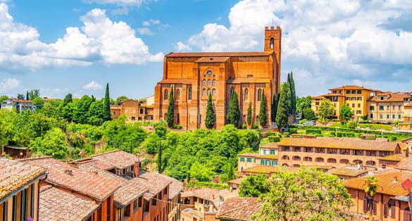 photo of view of Siena, medieval town in Tuscany, with view of the Dome Bell Tower of Siena Cathedral, Mangia Tower and Basilica of San Domenico, Italy