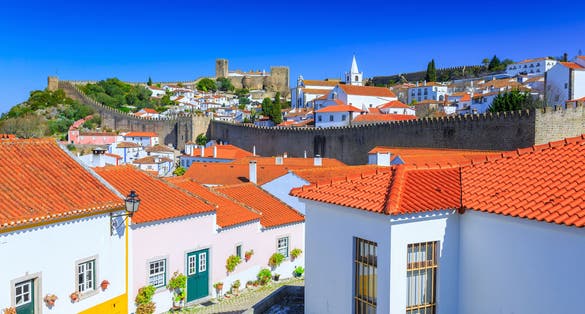 View of the beautiful medieval historic center village of Obidos and Castle of Obidos. Wonderful romantic afternoon landscape at sunny weather. District of Leiria, in the centre of Portugal.