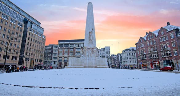 photo of snowy Damsquare in Amsterdam the Netherlands with the National Monument in winter.