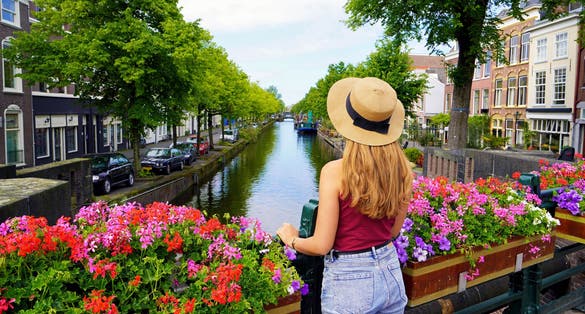 Tourism in Holland. Back view of beautiful fashion girl between flower pots in The Hague, Netherlands.
