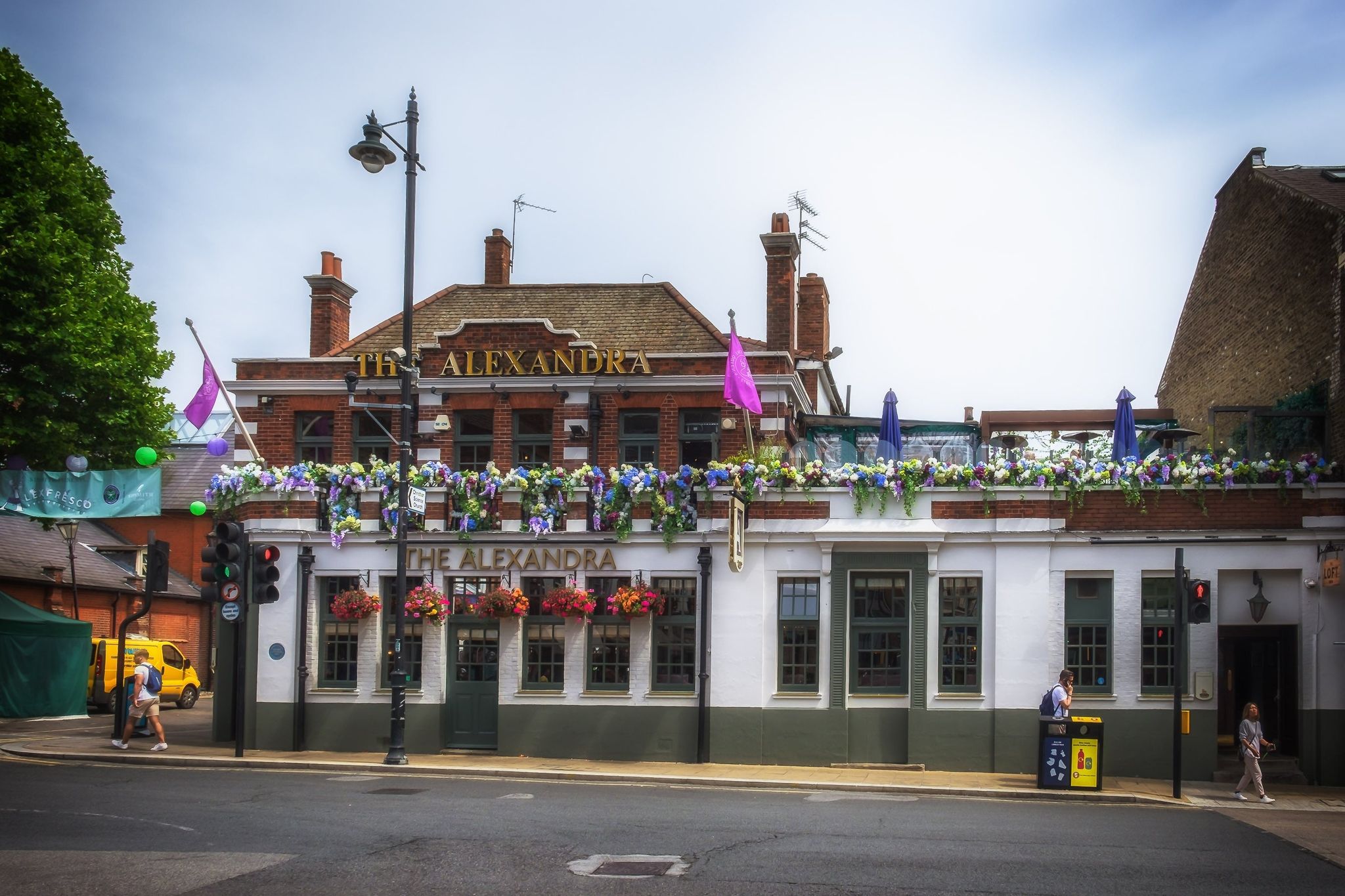 The Alexandra pub in Wimbledon decorated with colorful flowers and summer flags..jpg