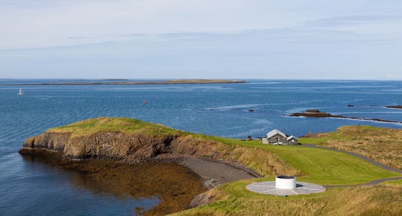 photo of view of The Imagine Peace Tower view from a hill above. Memorial to John Lennon from Yoko Ono. Videy Island near Reykjavik, Iceland..