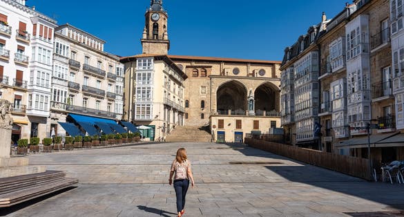Photo of Tourist woman walking through the large Plaza de la Virgen Blanca in the city of Vitoria, Spain.
