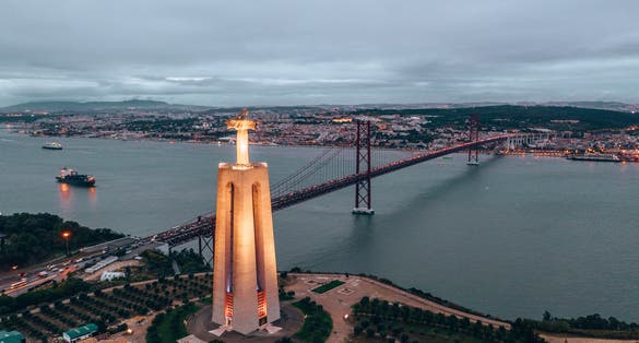Photo of Sanctuary of Christ the King at night in Lisbon, Portugal.
