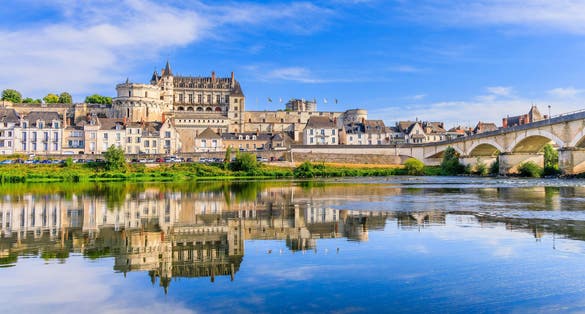 photo of view of Amboise, France. The walled town and Chateau of Amboise reflected in the River Loire.
