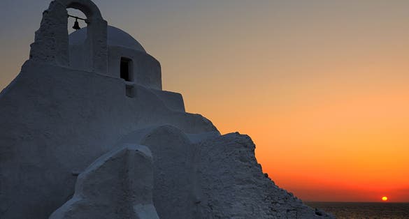 photo of view of Aerial drone top down photo of picturesque fishing boat near chapel of Paraportiani in iconic little Venice of Mykonos island, Cyclades, Greece.