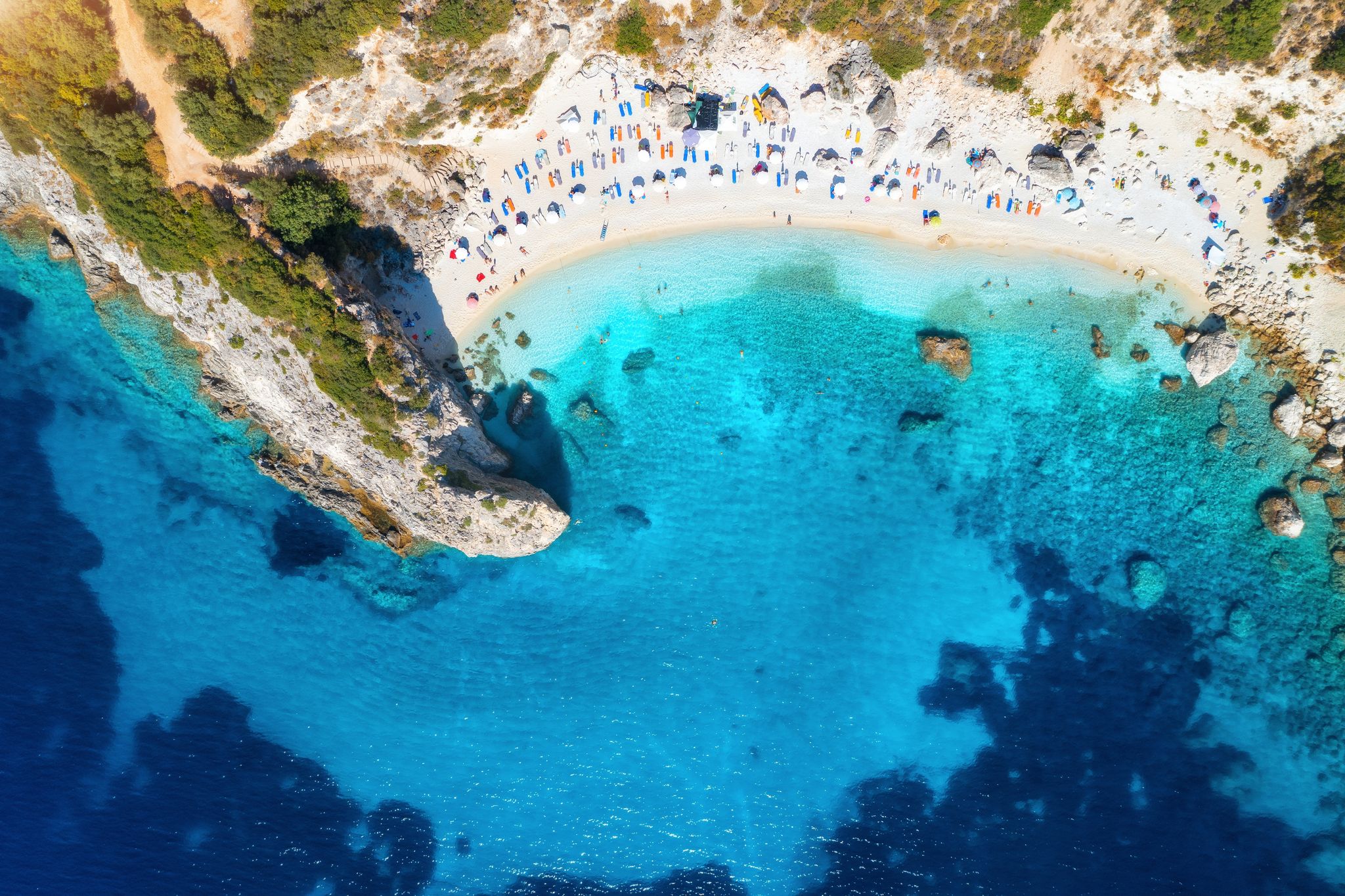 Photo of aerial view of Porto Katsiki blue sea, rock, sandy beach with umbrellas at sunrise in summer, Lefkada island, Greece. 