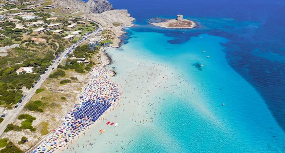 Stunning aerial view of the Spiaggia Della Pelosa (Pelosa Beach) full of colored beach umbrellas.