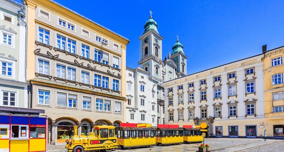 Photo of old Cathedral (Alter Dom) and tourist train in the Main Square, Linz, Austria. 