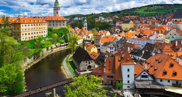 Photo of aerial view of houses and the wooden bridge over river Vltava, Český Krumlov, Czech Republic.