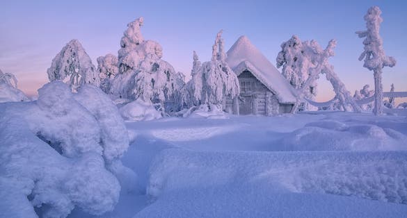 Photo of house in winter forest, Luosto, Finland.