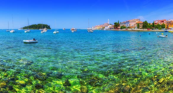 Photo of wonderful romantic old town at Adriatic sea. Boats and yachts in harbor crystal clear turquoise water at magical summer, Rovinj, Istria, Croatia.