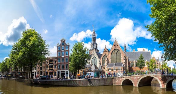 photo of Oude Kerk (Old Church) and Voorburgwal canal in Amsterdam.