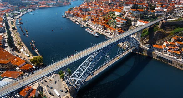 Photo of aerial view of the metal arch bridge (Dom Luise bridge) between the city of Porto and the city of Vila Nova de Gaia at sunny day, Portugal.