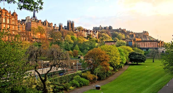 Photo of view of old Edinburgh, Scotland at sunset from Princes Street Gardens.