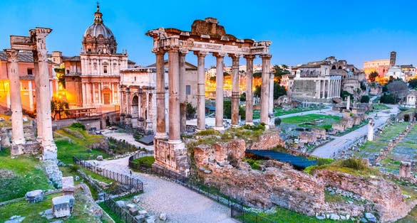 Rome, Italy. Stunning twilight view of Forum ancient ruins, seen from Capitoline hill with Colosseum in background.