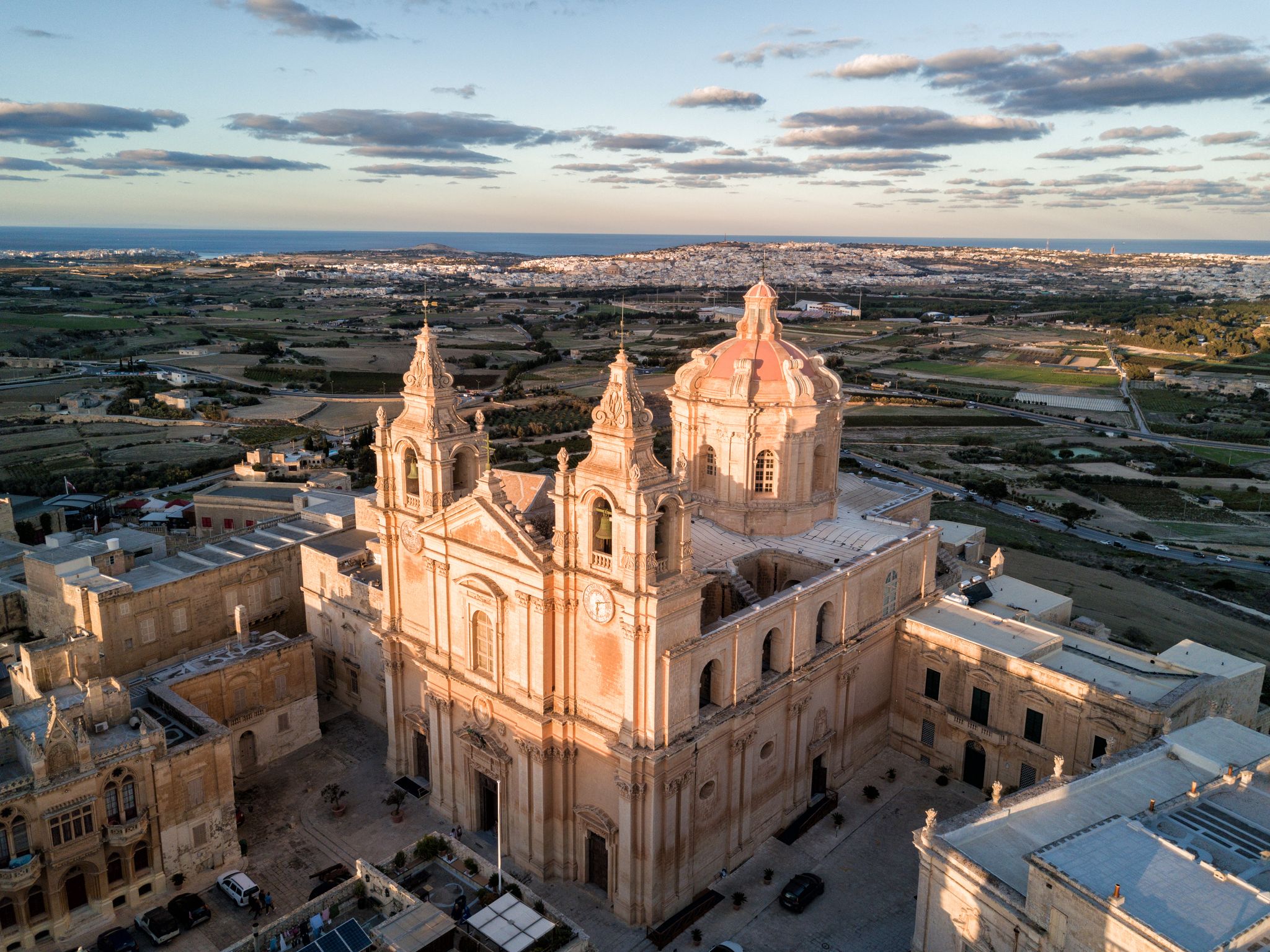 Photo of aerial drone view of St. Paul's Cathedral at sunset in the ancient medieval city of Mdina, Malta.