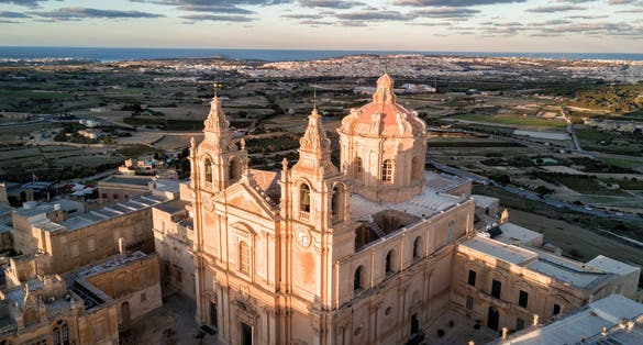Photo of aerial drone view of St. Paul's Cathedral at sunset in the ancient medieval city of Mdina, Malta.