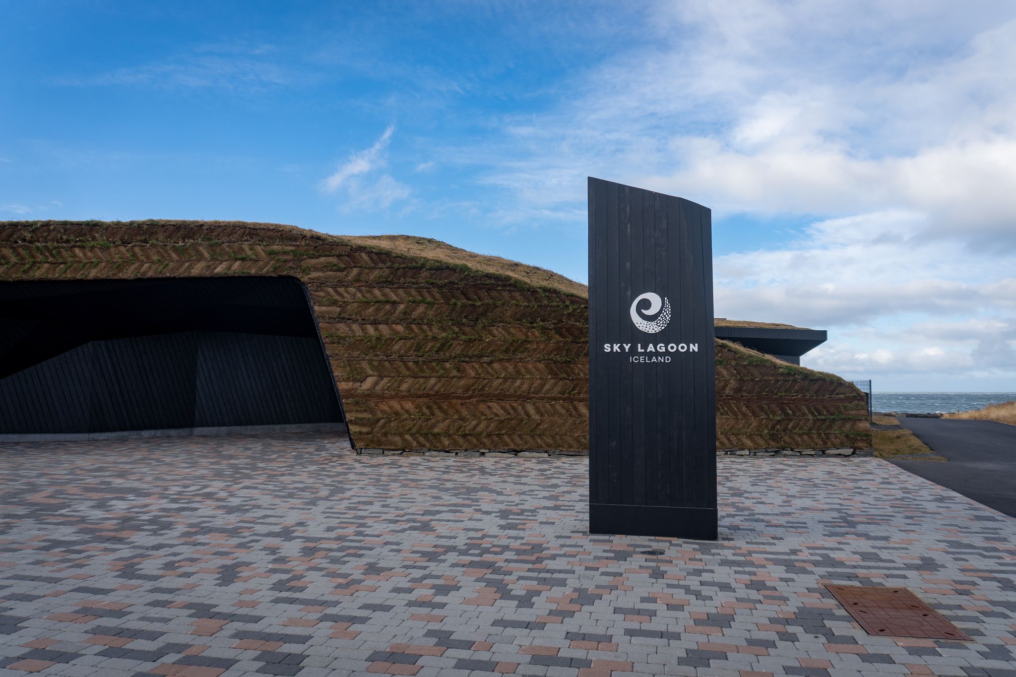 photo of Kópavogur, Iceland -2023: exterior of sky lagoon with sign and turf wall. Sky lagoon is a geothermal spa in southwestern Iceland.