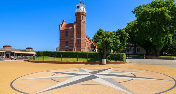 Brick lighthouse building compass rose square park, Ustka town, Baltic Sea, Poland