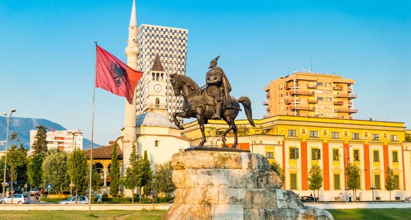 Skanderbeg square with flag, Skanderbeg monument and The Et'hem Bey Mosque in the center of Tirana city, Albania.