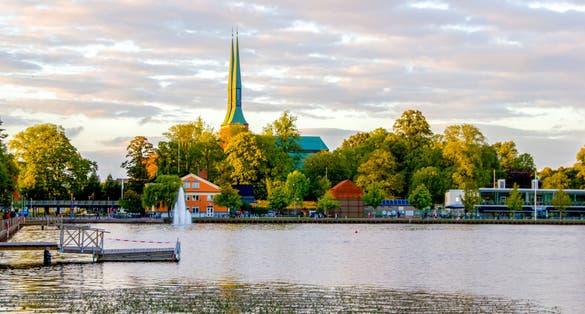 photo of aerial view of Växjö Cathedral from the Swedish lake on a sunny day with some clouds on the sky in Kronoberg County, Sweden.