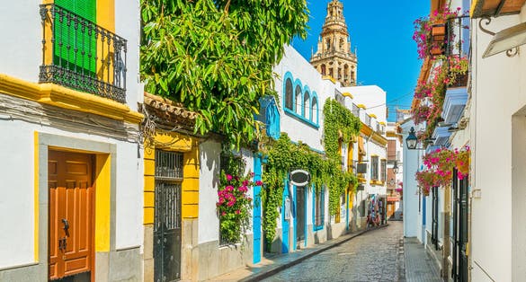 photo of view of Scenic sight in the picturesque Cordoba jewish quarter with the bell tower of the Mosque Cathedral. Andalusia, Spain.