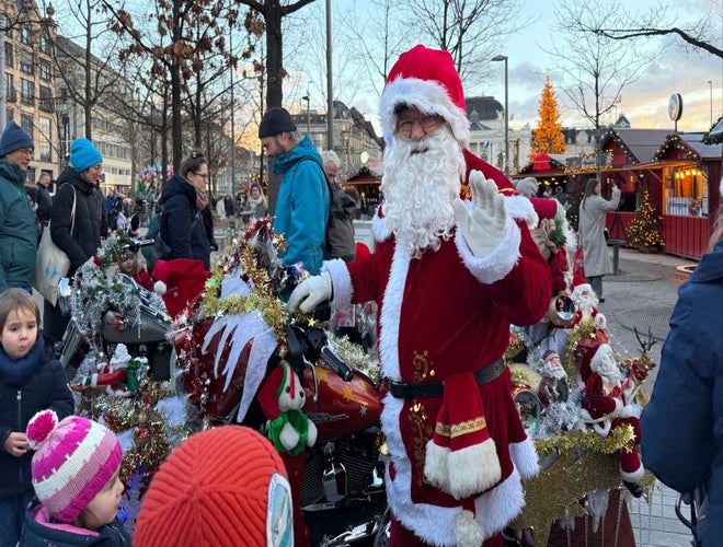 Santa Claus greeting children at a decorated Christmas market in Switzerland..jpg