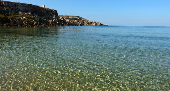 Photo of Golden bay beach on Malta island with calm transparent sea water.