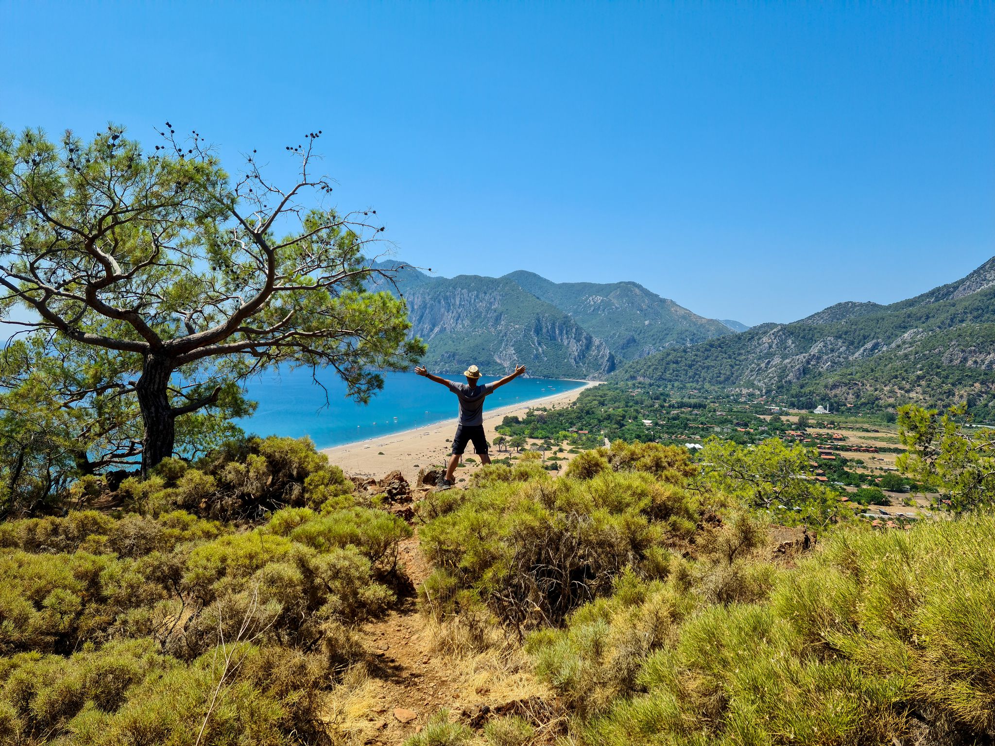 photo of man standing against the amazing view of of Olympos and Cirali beach in Antalya ,Turkey.