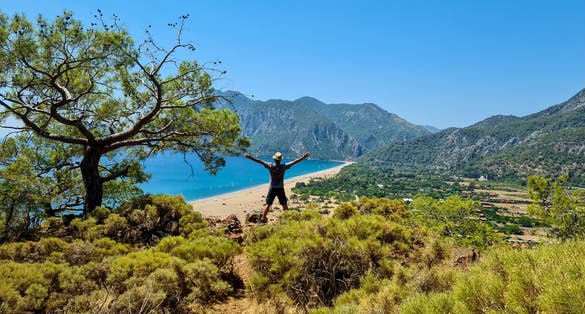 photo of man standing against the amazing view of of Olympos and Cirali beach in Antalya ,Turkey.