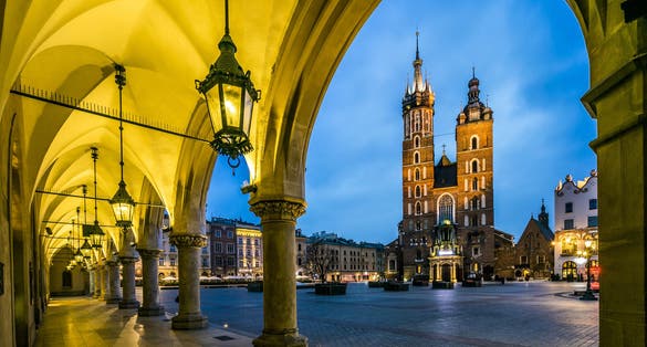 Photo of Illuminated Krakow market square at dawn, Poland.