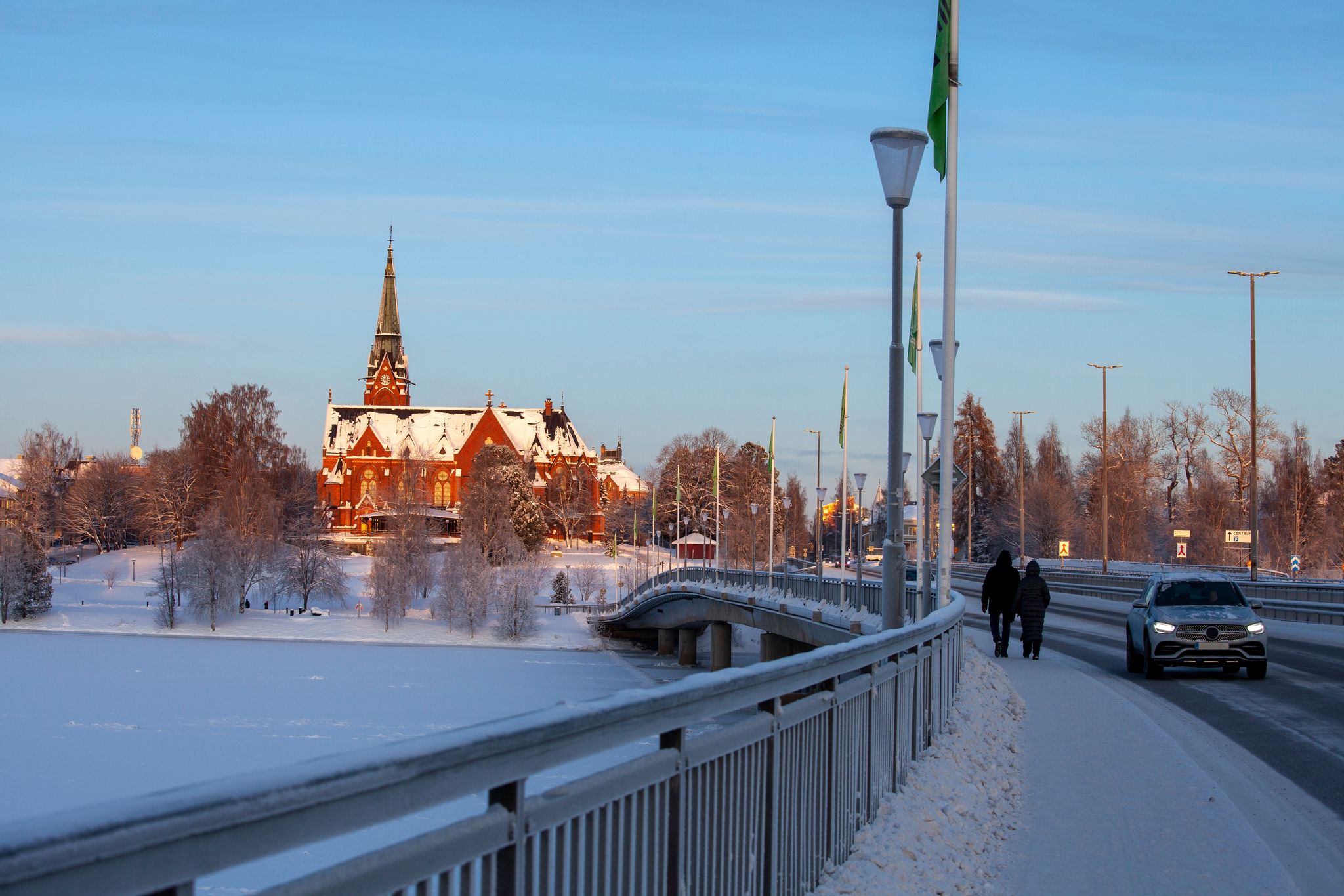 photo of sun and snow on Umeå City Church from 1894 in Umeå in north of Sweden, with the bridge across the frozen river in the front.