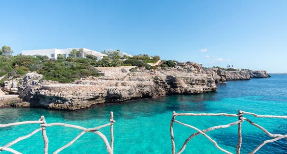 photo of the beautiful turquoise waters of Cala en Brut, Menorca beach, Balearic Islands, Spain.