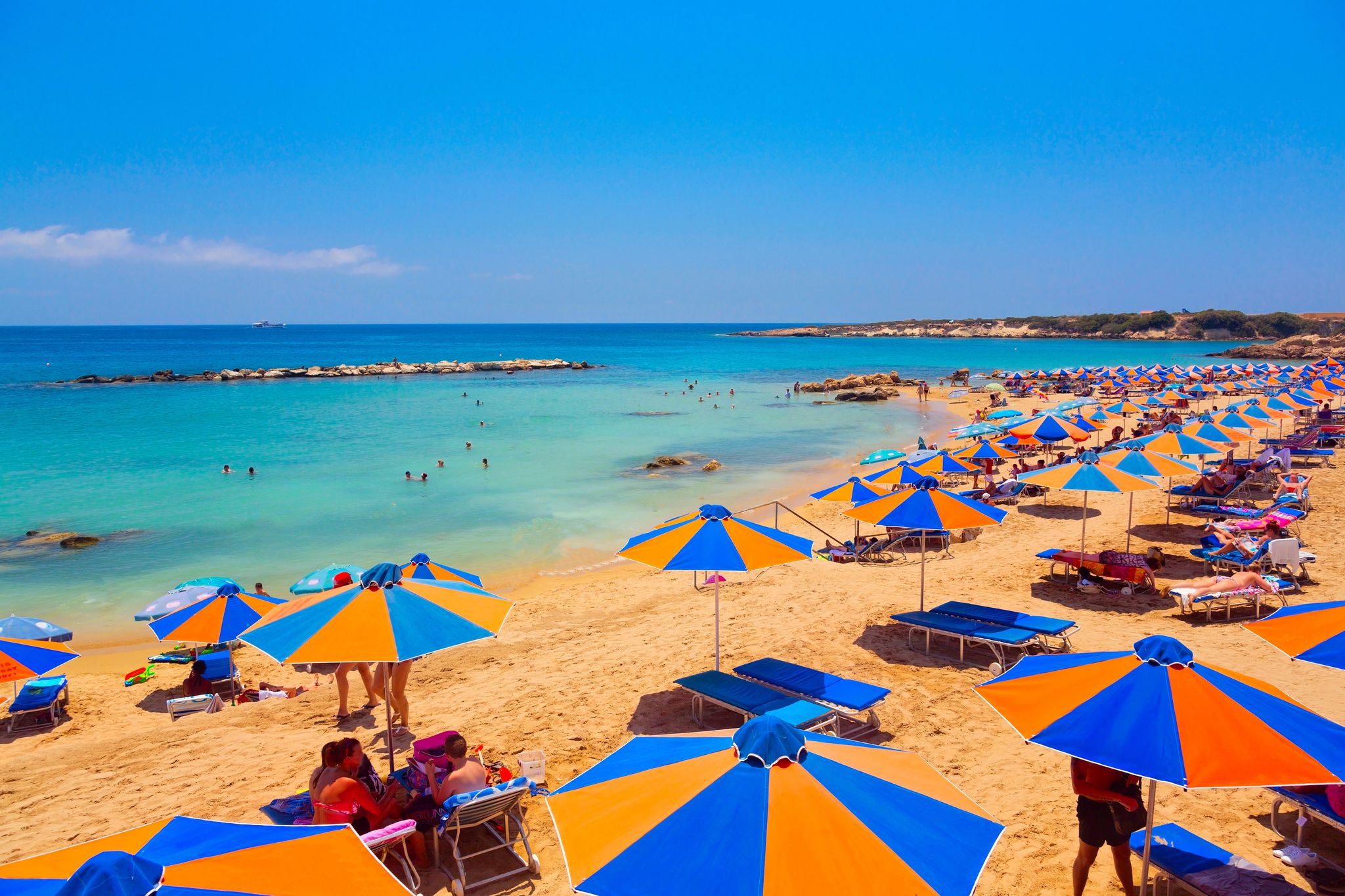 Photo of Coral Bay Beach with sunbeds and umbrellas in Paphos, Cyprus.