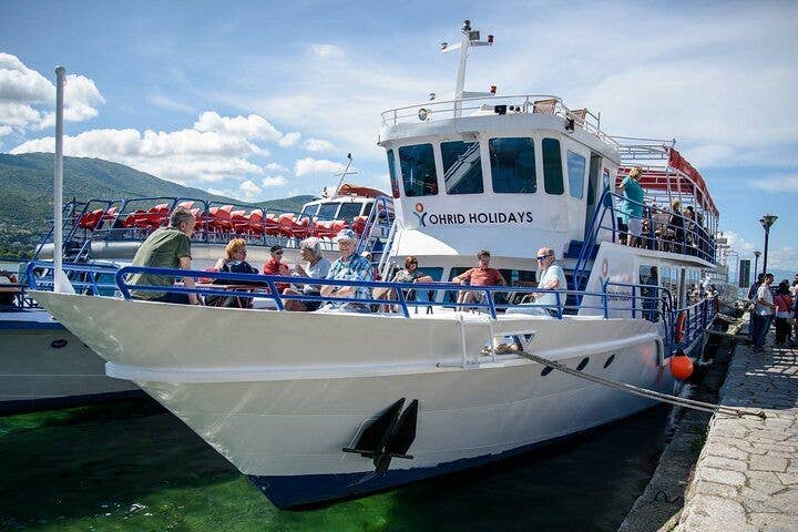 A tourist boat docked at the pier with passengers enjoying the view in Ohrid, North Macedonia..jpg