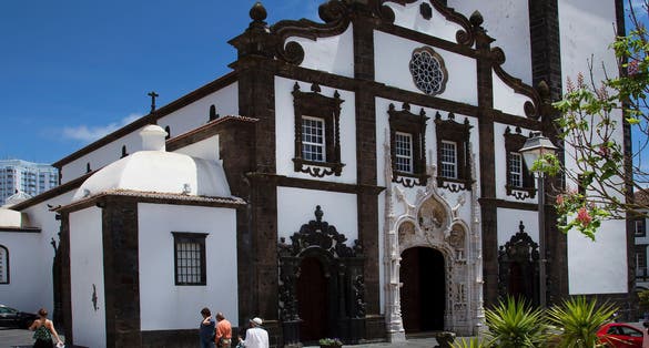 Ponta Delgada city center church with decorative pavement design pattern and street furniture.